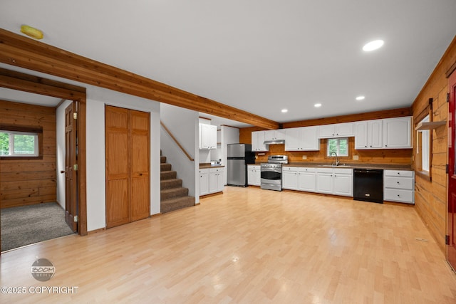 1291 N Rainbow Park Dr, Wasilla, AK 99623 - kitchen with appliances with stainless steel finishes, wood walls, plenty of natural light, light wood-type flooring, and white cabinetry