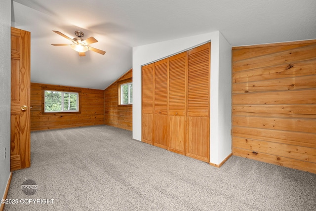 1291 N Rainbow Park Dr, Wasilla, AK 99623 - unfurnished bedroom featuring wood walls, lofted ceiling, carpet flooring, a closet, and ceiling fan
