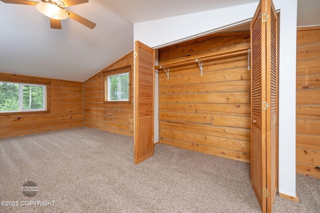 1291 N Rainbow Park Dr, Wasilla, AK 99623 - unfurnished bedroom with multiple windows, lofted ceiling, carpet floors, wooden walls, and a closet