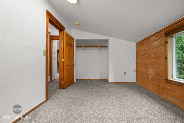 1291 N Rainbow Park Dr, Wasilla, AK 99623 - unfurnished bedroom with vaulted ceiling, light carpet, a closet, a textured ceiling, and wooden walls