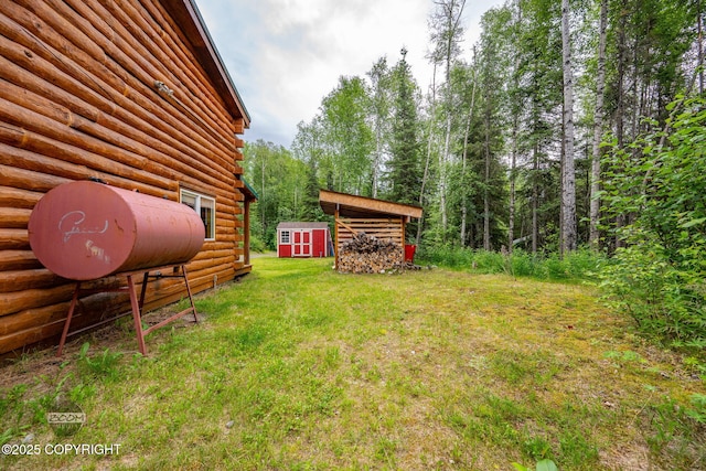 1291 N Rainbow Park Dr, Wasilla, AK 99623 - view of grassy yard with a storage shed and a wooded view