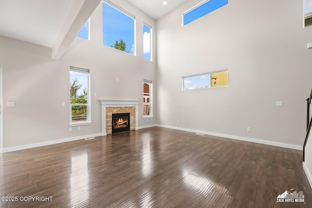 8126 Grayhawk Cir, Anchorage, AK 99507 - unfurnished living room with dark wood-style flooring, a fireplace, and a high ceiling
