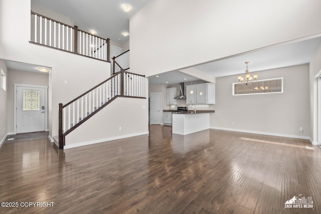 8126 Grayhawk Cir, Anchorage, AK 99507 - unfurnished living room featuring a chandelier, dark wood-style floors, a towering ceiling, and stairway