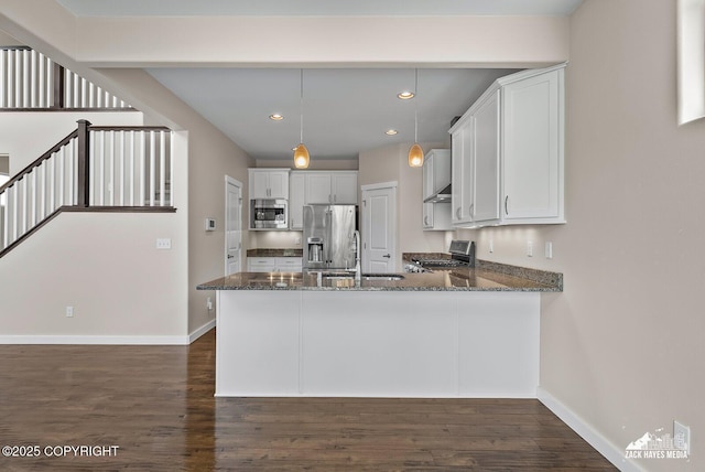 8126 Grayhawk Cir, Anchorage, AK 99507 - kitchen with appliances with stainless steel finishes, dark stone counters, dark wood-type flooring, a peninsula, and recessed lighting