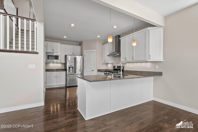 8126 Grayhawk Cir, Anchorage, AK 99507 - kitchen featuring appliances with stainless steel finishes, wall chimney range hood, a peninsula, dark stone countertops, and dark wood finished floors