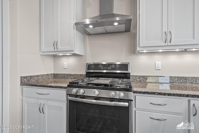8126 Grayhawk Cir, Anchorage, AK 99507 - kitchen featuring gas stove, wall chimney exhaust hood, white cabinetry, and dark stone counters
