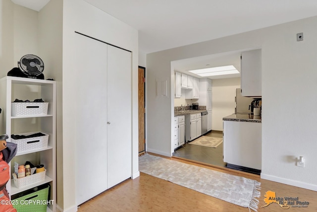 1201 Denali St Unit 210, Anchorage, AK 99501 - kitchen with wood finished floors, dishwasher, and white cabinets