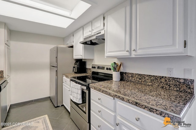 1201 Denali St Unit 210, Anchorage, AK 99501 - kitchen with stainless steel range with electric stovetop, under cabinet range hood, white cabinets, tile patterned floors, and freestanding refrigerator