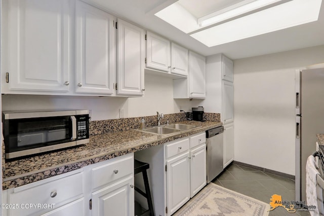 1201 Denali St Unit 210, Anchorage, AK 99501 - kitchen featuring stainless steel appliances, white cabinetry, and dark tile patterned floors