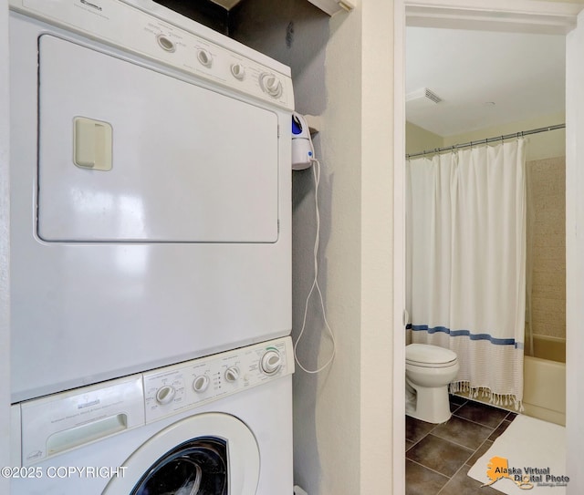 1201 Denali St Unit 210, Anchorage, AK 99501 - washroom featuring estacked washer and dryer and tile patterned floors