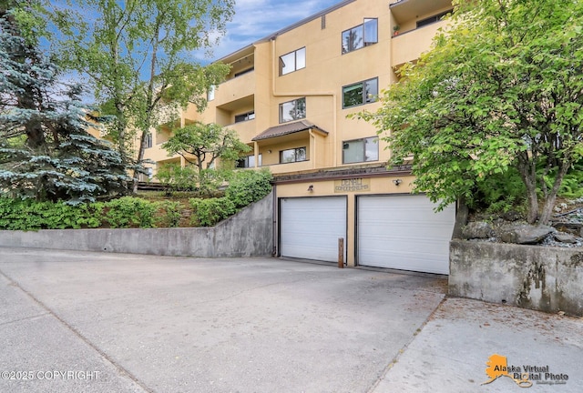1201 Denali St Unit 210, Anchorage, AK 99501 - view of building exterior with concrete driveway and a garage