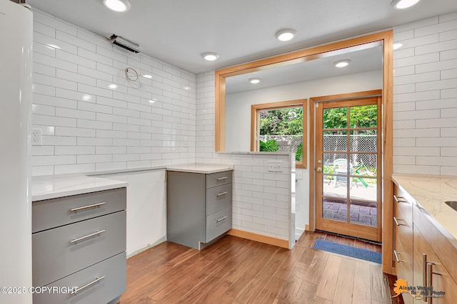 2641 W 27th Ave, Anchorage, AK 99517 - kitchen featuring gray cabinetry, light stone countertops, wood finished floors, tasteful backsplash, and recessed lighting