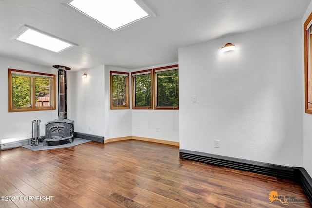 2641 W 27th Ave, Anchorage, AK 99517 - empty room featuring a wood stove and wood finished floors