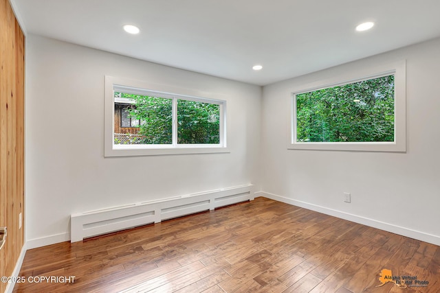 2641 W 27th Ave, Anchorage, AK 99517 - unfurnished room featuring healthy amount of natural light, wood finished floors, a baseboard heating unit, and recessed lighting