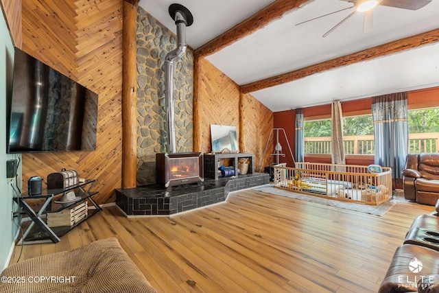 22432 Glacier View Dr, Eagle River, AK 99577 - living area with a wood stove, wood walls, ceiling fan, hardwood / wood-style floors, and beam ceiling