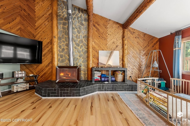 22432 Glacier View Dr, Eagle River, AK 99577 - living area with a wood stove, wooden walls, beam ceiling, and wood finished floors