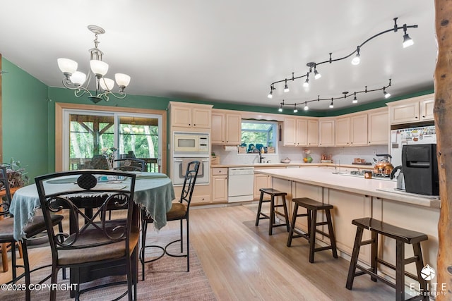 22432 Glacier View Dr, Eagle River, AK 99577 - kitchen with white appliances, a chandelier, a kitchen breakfast bar, light wood finished floors, and light countertops