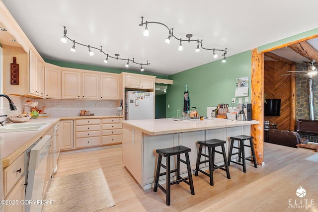 22432 Glacier View Dr, Eagle River, AK 99577 - kitchen with white appliances, light wood finished floors, a peninsula, a kitchen bar, and decorative backsplash