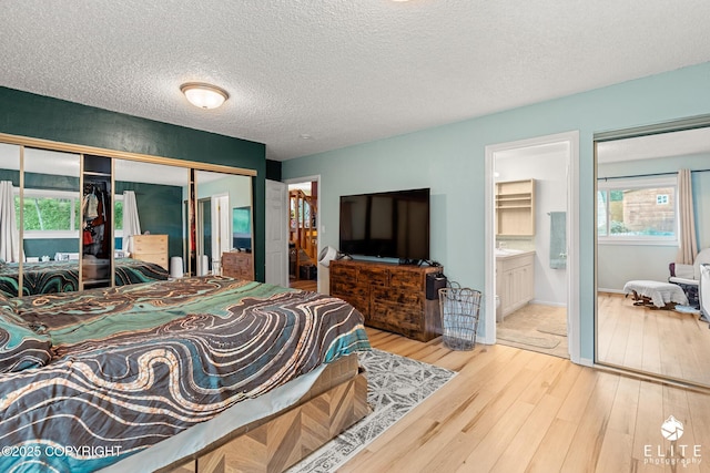 22432 Glacier View Dr, Eagle River, AK 99577 - bedroom with wood finished floors, a closet, a textured ceiling, and ensuite bathroom