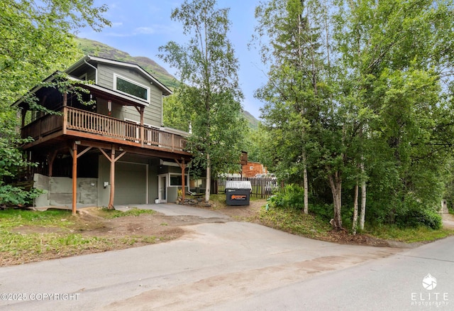 22432 Glacier View Dr, Eagle River, AK 99577 - rustic home featuring a garage, concrete driveway, and a deck