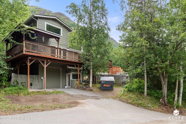 22432 Glacier View Dr, Eagle River, AK 99577 - chalet / cabin with a deck with mountain view, driveway, and an attached garage