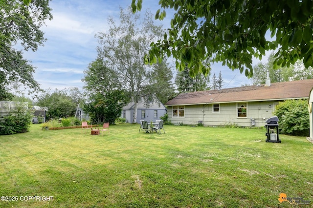 4905 Roger Dr, Anchorage, AK 99507 - view of green lawn featuring a fire pit and an outbuilding