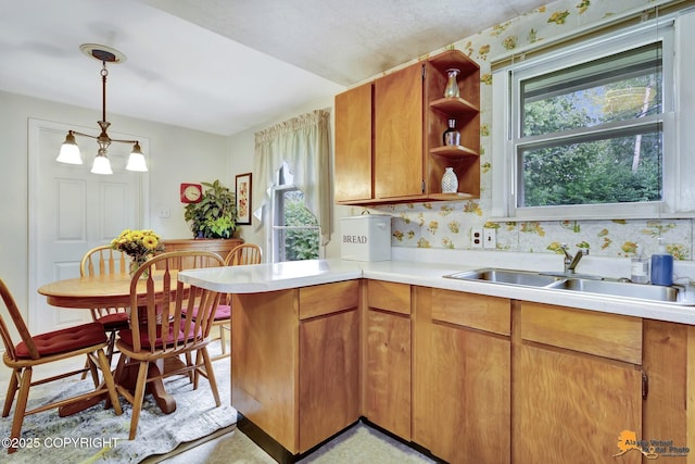 4905 Roger Dr, Anchorage, AK 99507 - kitchen with light countertops, brown cabinetry, a peninsula, open shelves, and pendant lighting