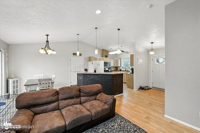 34443 Matanuska St, Soldotna, AK 99669 - living room featuring light wood finished floors, a textured ceiling, a chandelier, and vaulted ceiling