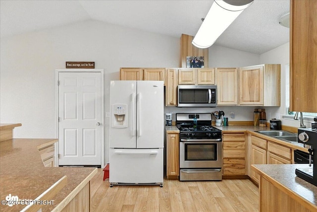 34443 Matanuska St, Soldotna, AK 99669 - kitchen with vaulted ceiling, light brown cabinets, appliances with stainless steel finishes, and light wood-type flooring