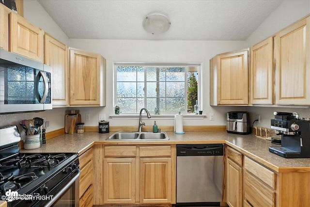 34443 Matanuska St, Soldotna, AK 99669 - kitchen featuring light brown cabinetry, appliances with stainless steel finishes, a textured ceiling, and light countertops