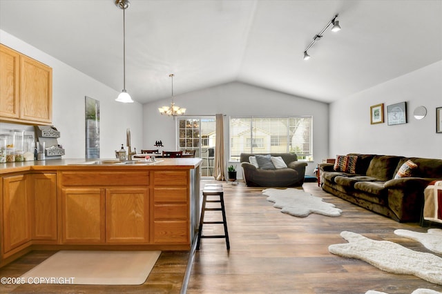 5586 Sapphire Loop # 55B, Anchorage, AK 99504 - kitchen with open floor plan, vaulted ceiling, a peninsula, wood finished floors, and a chandelier
