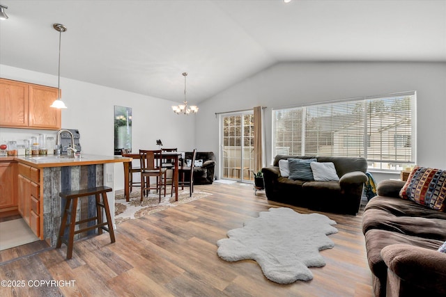 5586 Sapphire Loop # 55B, Anchorage, AK 99504 - living room with light wood-style floors, a chandelier, and vaulted ceiling
