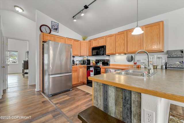 5586 Sapphire Loop # 55B, Anchorage, AK 99504 - kitchen with black appliances, vaulted ceiling, a peninsula, wood finished floors, and track lighting