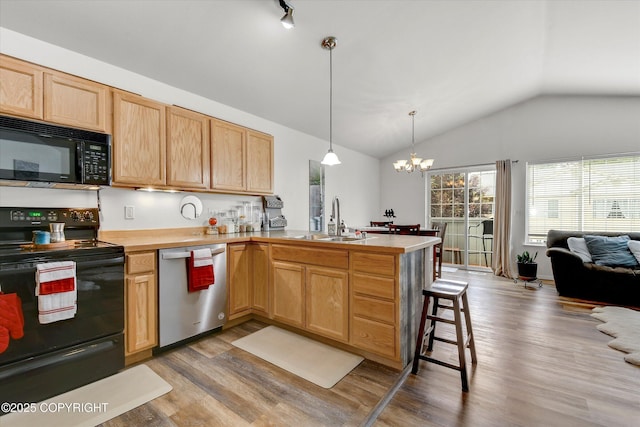 5586 Sapphire Loop # 55B, Anchorage, AK 99504 - kitchen with black appliances, vaulted ceiling, a peninsula, wood finished floors, and a chandelier