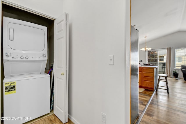 5586 Sapphire Loop # 55B, Anchorage, AK 99504 - laundry area with stacked washer and clothes dryer, a chandelier, and light wood-type flooring