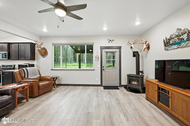 5551 N Wildwood Dr, Wasilla, AK 99654 - living room featuring a wood stove, light wood-style flooring, a ceiling fan, and recessed lighting