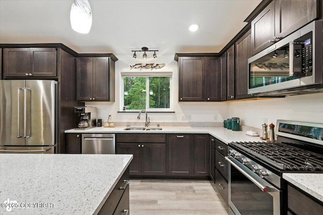 5551 N Wildwood Dr, Wasilla, AK 99654 - kitchen with stainless steel appliances, dark brown cabinetry, light stone countertops, light wood-type flooring, and recessed lighting