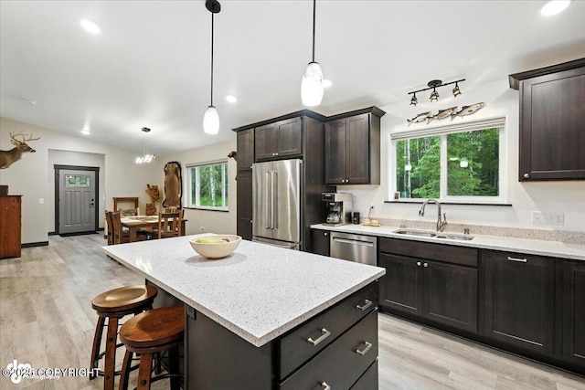 5551 N Wildwood Dr, Wasilla, AK 99654 - kitchen featuring stainless steel appliances, a kitchen island, light wood-style floors, a kitchen breakfast bar, and hanging light fixtures