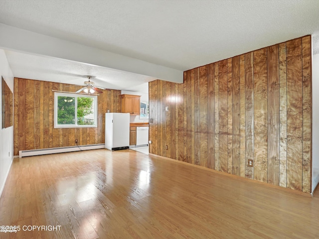 9801 Whitefish Cir, Anchorage, AK 99515 - unfurnished living room featuring baseboard heating, wood walls, light wood finished floors, ceiling fan, and a textured ceiling
