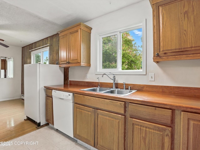 9801 Whitefish Cir, Anchorage, AK 99515 - kitchen with dishwasher, brown cabinets, ceiling fan, light tile patterned flooring, and a baseboard heating unit