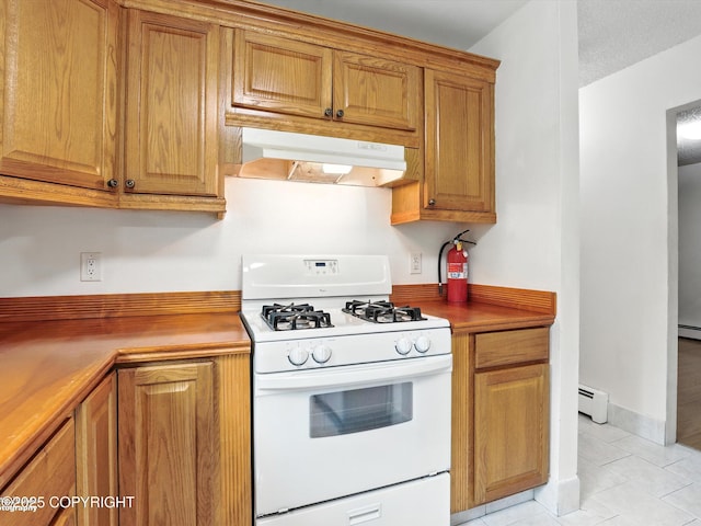 9801 Whitefish Cir, Anchorage, AK 99515 - kitchen with white gas stove, under cabinet range hood, a baseboard radiator, and brown cabinetry