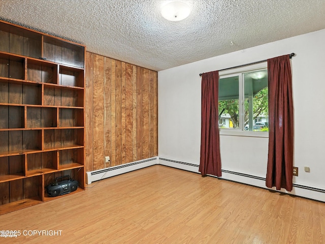 9801 Whitefish Cir, Anchorage, AK 99515 - unfurnished room featuring wood finished floors, a textured ceiling, baseboard heating, and wood walls