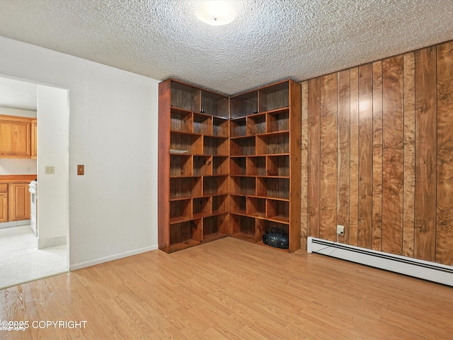 9801 Whitefish Cir, Anchorage, AK 99515 - wine room with light wood-style flooring, a baseboard heating unit, and a textured ceiling