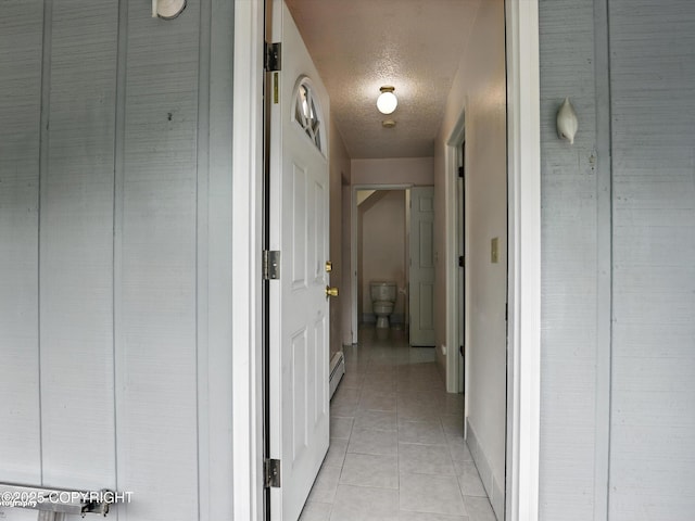 9801 Whitefish Cir, Anchorage, AK 99515 - hallway with a textured ceiling, a baseboard radiator, and light tile patterned floors