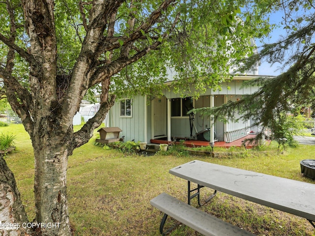 9801 Whitefish Cir, Anchorage, AK 99515 - view of front facade featuring board and batten siding, a front yard, and covered porch