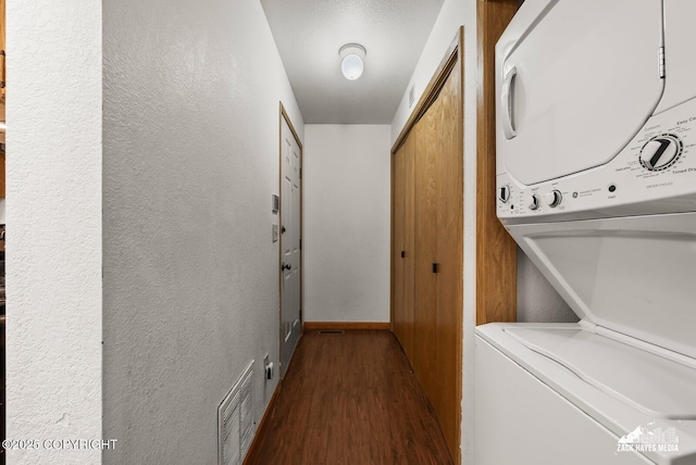 8641 Blackberry St # 6B, Anchorage, AK 99502 - laundry area with estacked washer and dryer, wood finished floors, and a textured wall