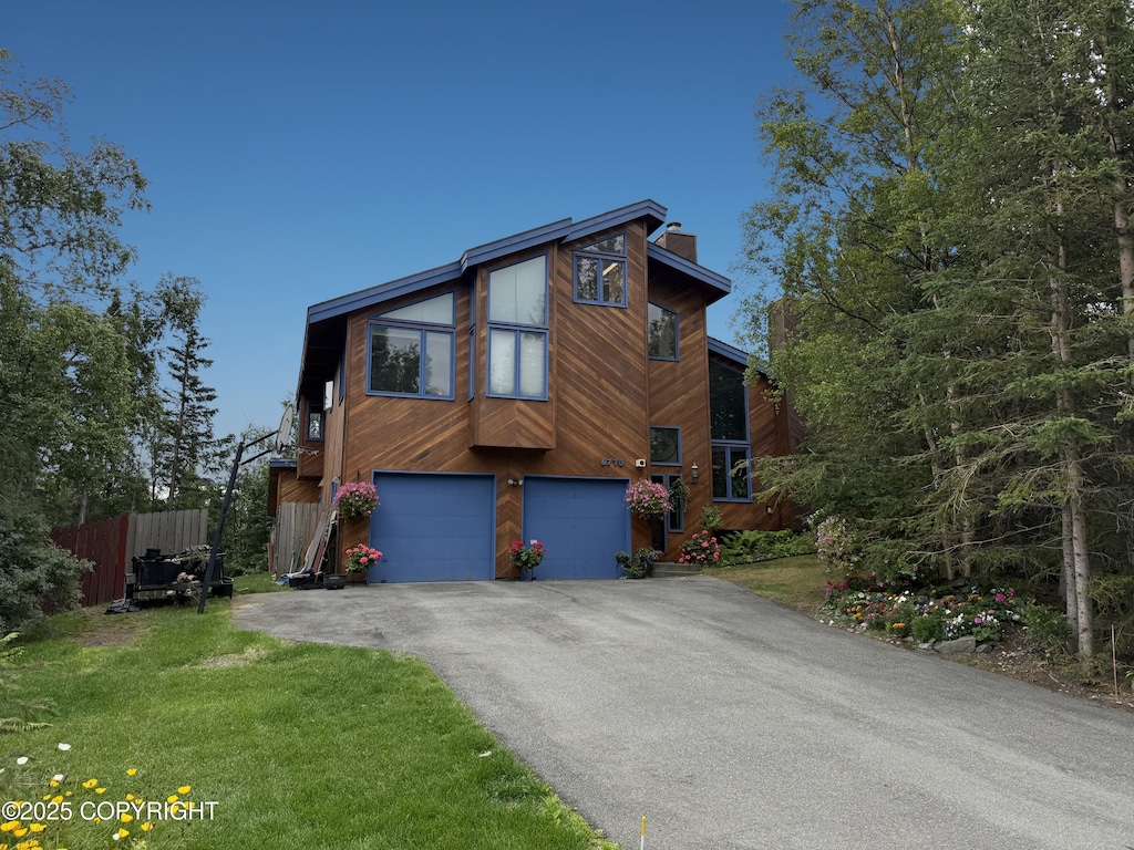 6770 Round Tree Dr, Anchorage, AK 99507 - view of front of home with a chimney, driveway, and an attached garage