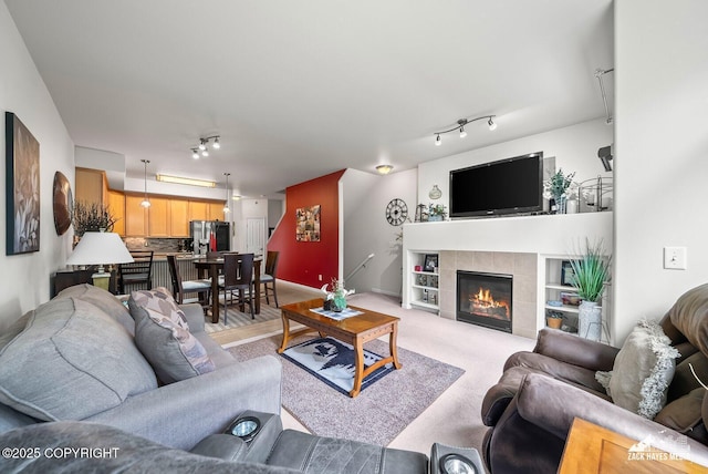 7655 Stepping Stone Ln Unit Q2, Anchorage, AK 99504 - living room featuring track lighting, a fireplace, and light carpet