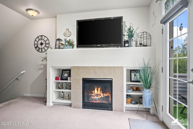 7655 Stepping Stone Ln Unit Q2, Anchorage, AK 99504 - living room featuring carpet floors, a tile fireplace, and built in shelves