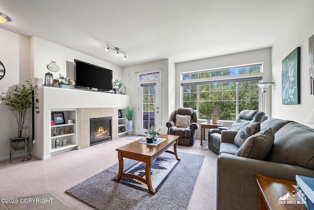 7655 Stepping Stone Ln Unit Q2, Anchorage, AK 99504 - carpeted living room with a tiled fireplace and healthy amount of natural light